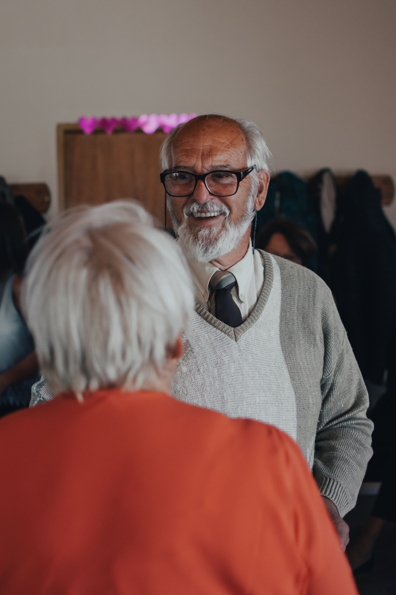 An older man smiling warmly in conversation with a loved one