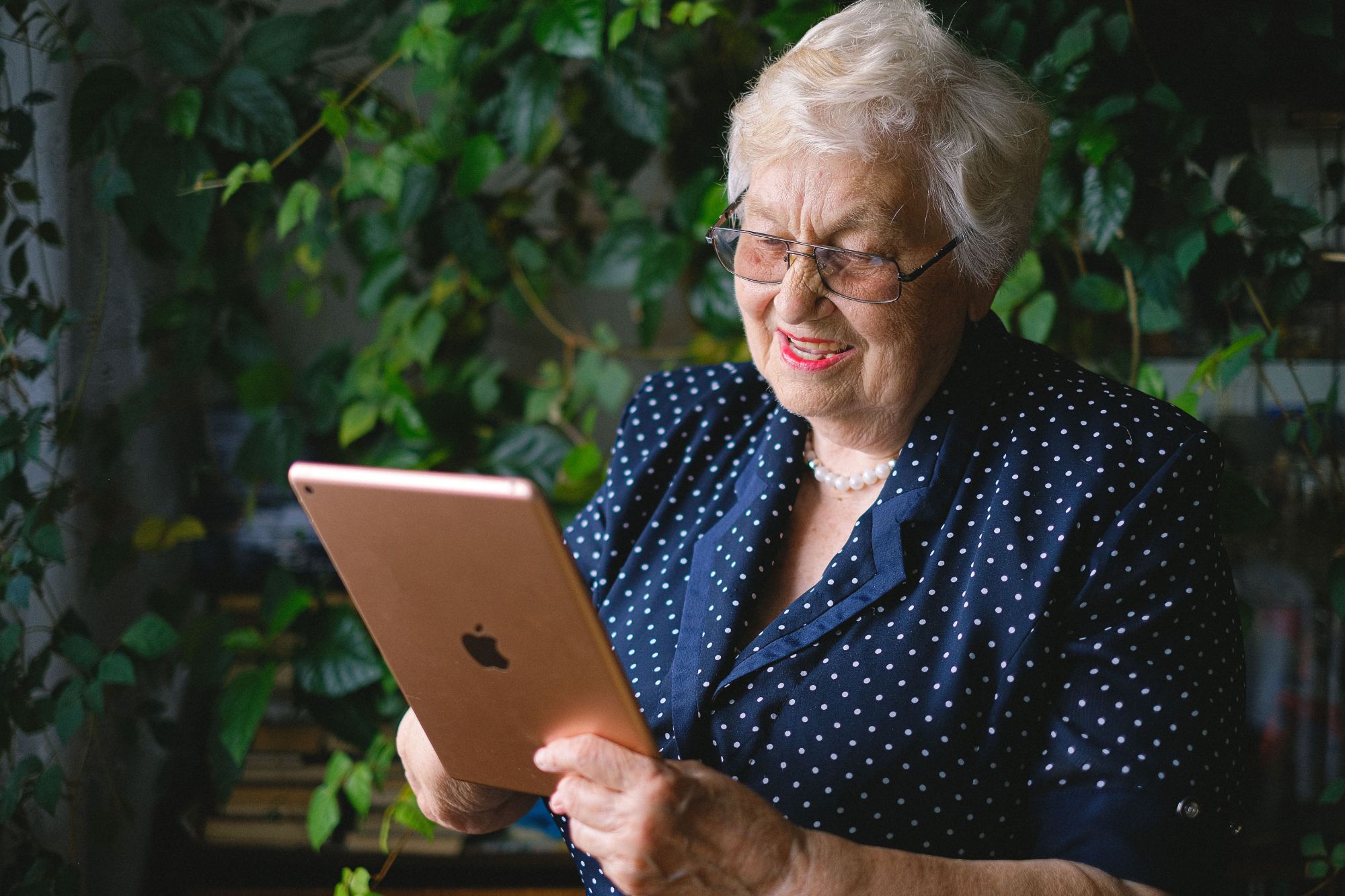 An older woman using a tablet at home